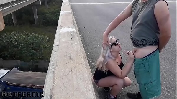 Rubia casada chupando a un amigo en el puente de la carretera